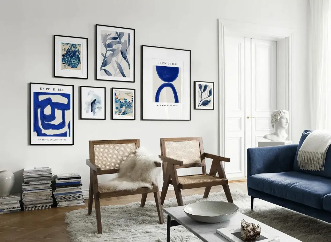 Un salon moderne avec un tableau bleu et blanc abstrait, des chaises en rotin et un canap&eacute; bleu.