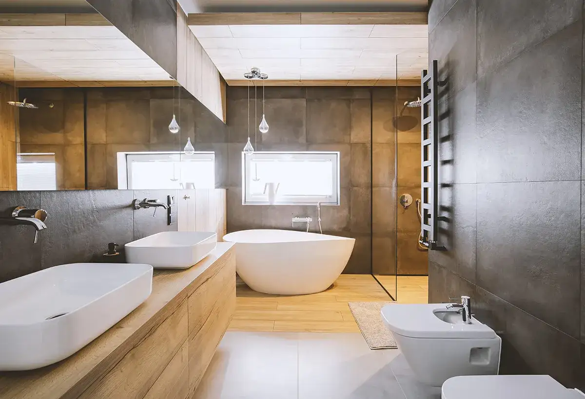 Salle de bain en longueur avec deux lavabos, une baignoire &icirc;lot, une douche et un bidet. Ambiance moderne et &eacute;pur&eacute;e.