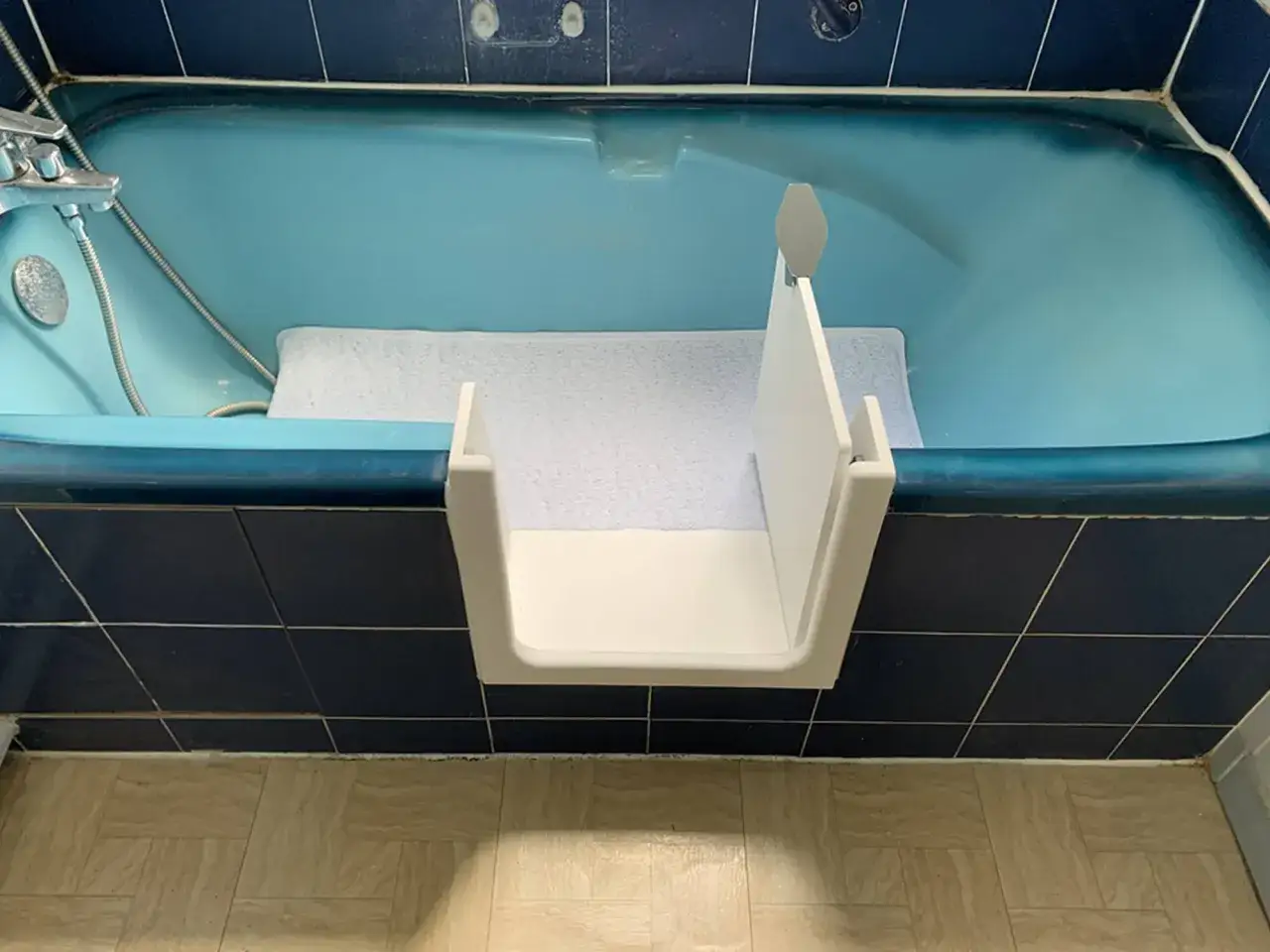 Adaptateur blanc pour baignoire en fonte, facilitant l'acc&egrave;s. Le poids de la baignoire en fonte assure sa stabilit&eacute;.