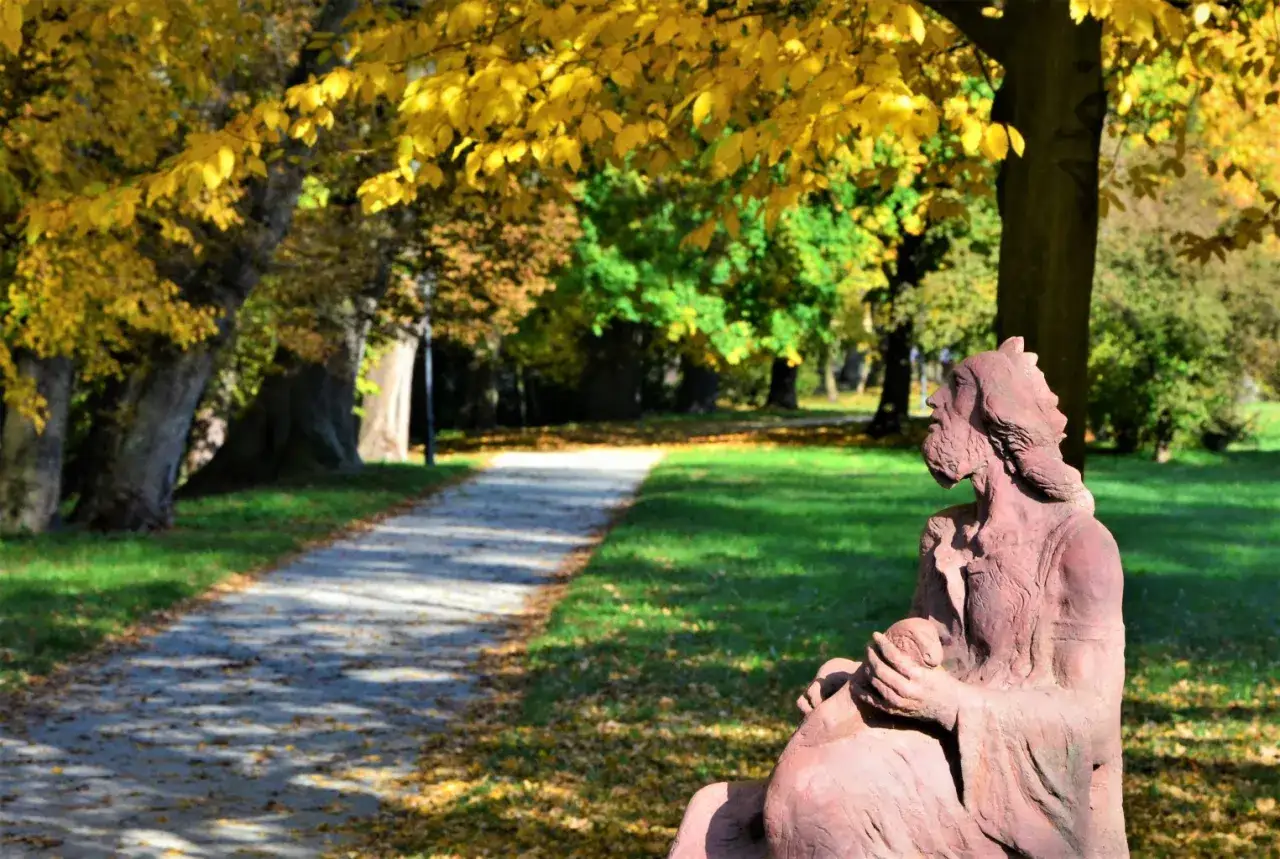 Jesienna aleja w Radziejowicach, z rzeźbą w parku. Piękne radziejowickie atrakcje w złotej odsłonie.