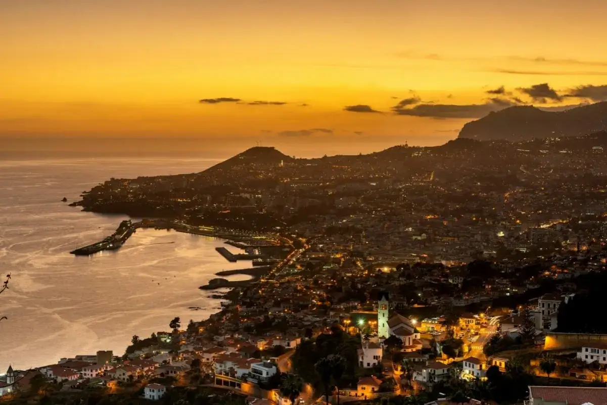Zachód słońca nad Funchal, Madera grudzień. Miasto rozświetlone tysiącami świateł, port i ocean w złotej poświacie.