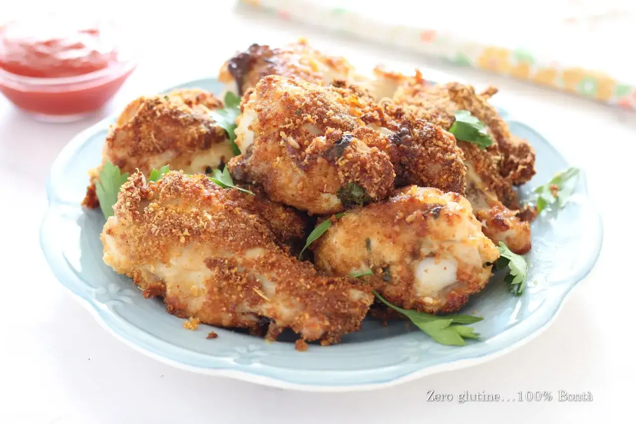 Alette di pollo croccanti in friggitrice ad aria, servite su un piatto azzurro con prezzemolo fresco e una ciotolina di ketchup.