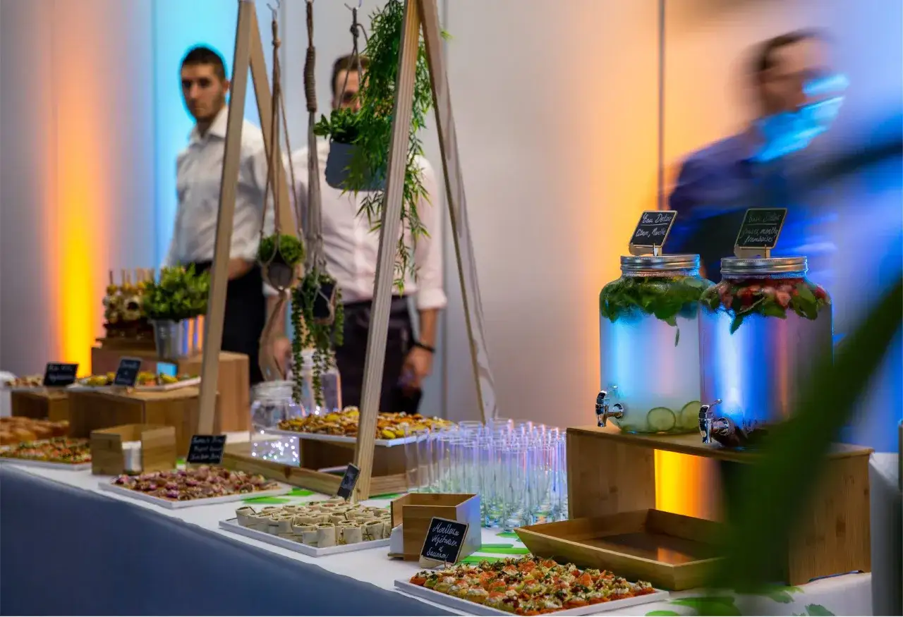 Buffet avec des boissons detox et des amuse-bouches. Une liste organisation des plats est visible.