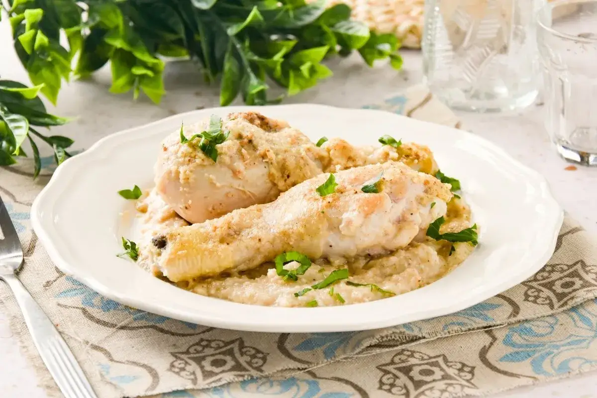 Pollo cremoso ba&ntilde;ado en una rica salsa de almendras, adornado con perejil fresco.
