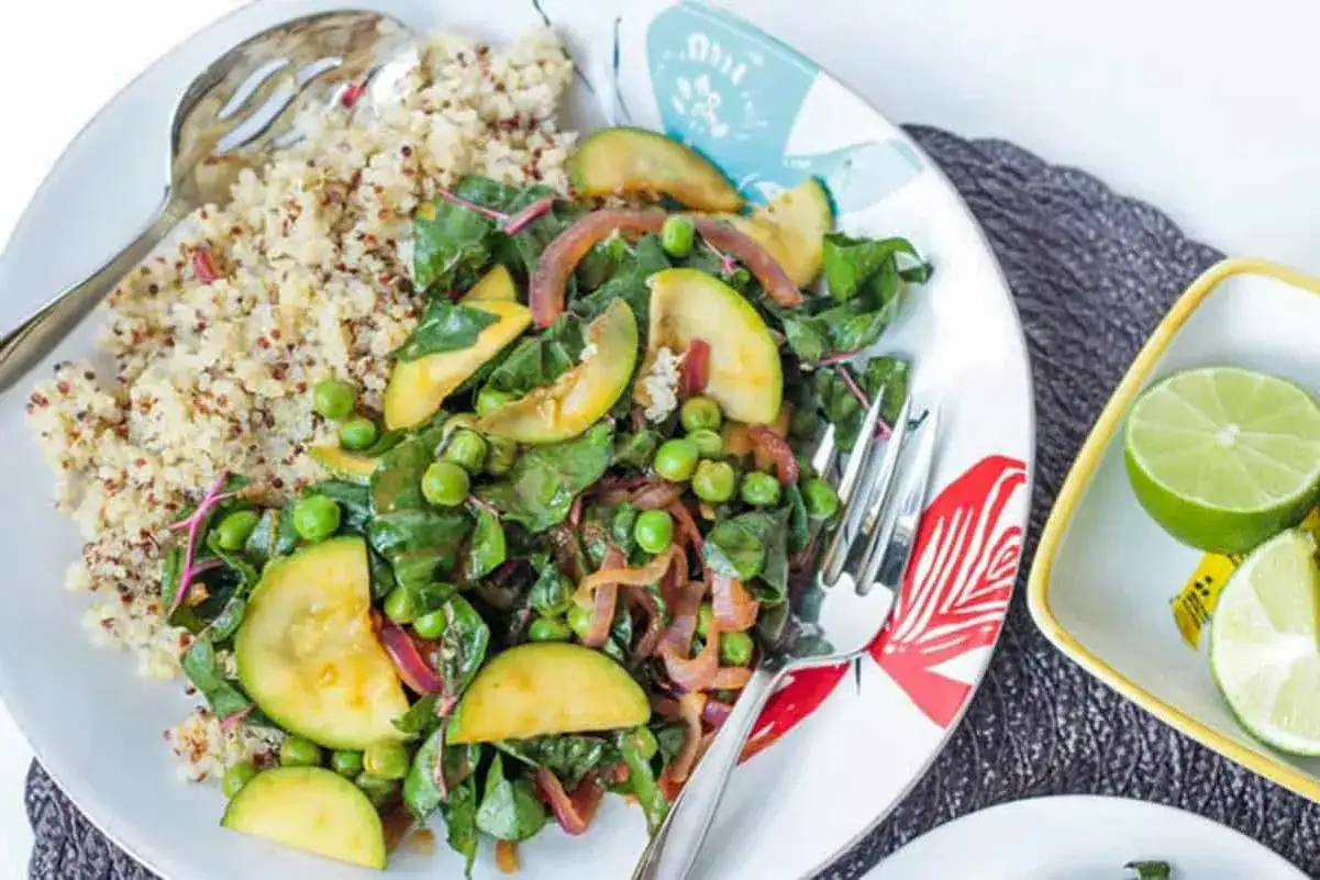 Plato de quinoa con verduras salteadas, guisantes y rodajas de calabacín. Una deliciosa receta con quinoa, perfecta para una comida saludable.