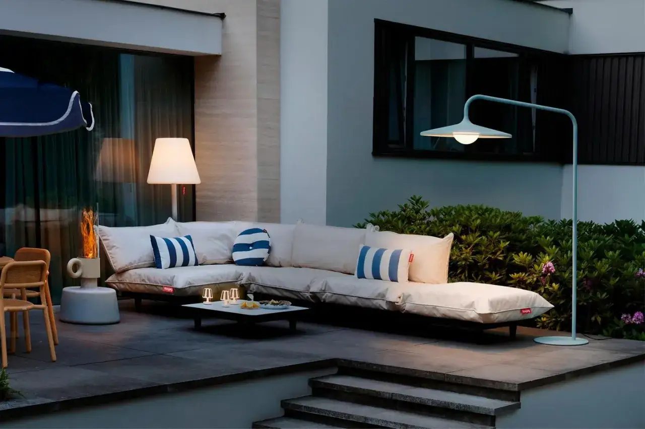 Gemütliche WPC Terrasse Ideen: Lounge-Ecke mit bequemen Sitzmöbeln, Kamin und Beleuchtung für laue Abende.