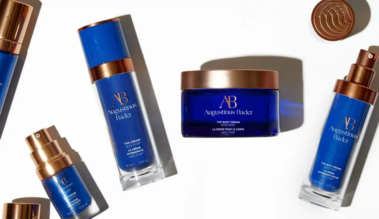 Rituel de soin visage avant mariage : flacons et pot de cr&egrave;me Augustinus Bader bleus et dor&eacute;s, pour une peau radieuse.