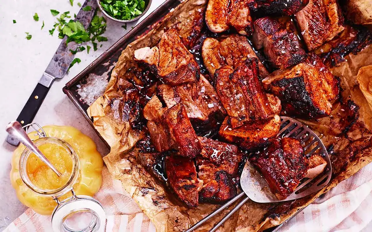 Saftiga, grillade revben med en härlig glans, redo att serveras med äppelmos.