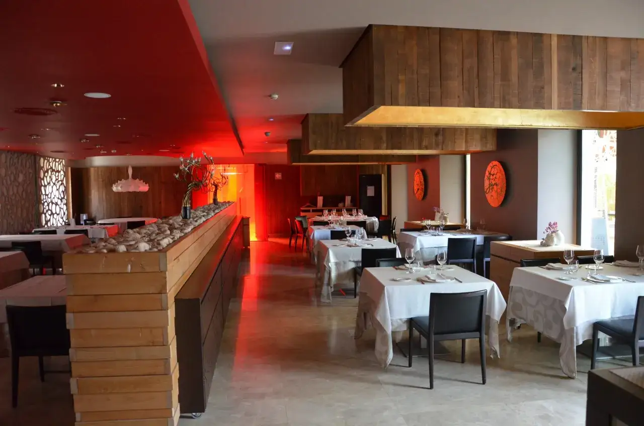Ein elegantes Restaurant mit roten Akzenten und Holzelementen. Hier k&ouml;nnte ein Sommelier die Bedeutung von Wein und Speisen erkl&auml;ren.