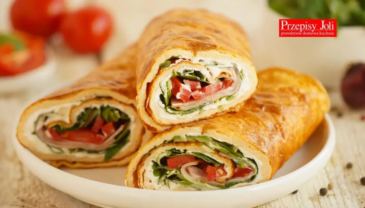 Złocista tortilla z serka wiejskiego, wypełniona szynką, pomidorami i rukolą. Pyszna i lekka przekąska.