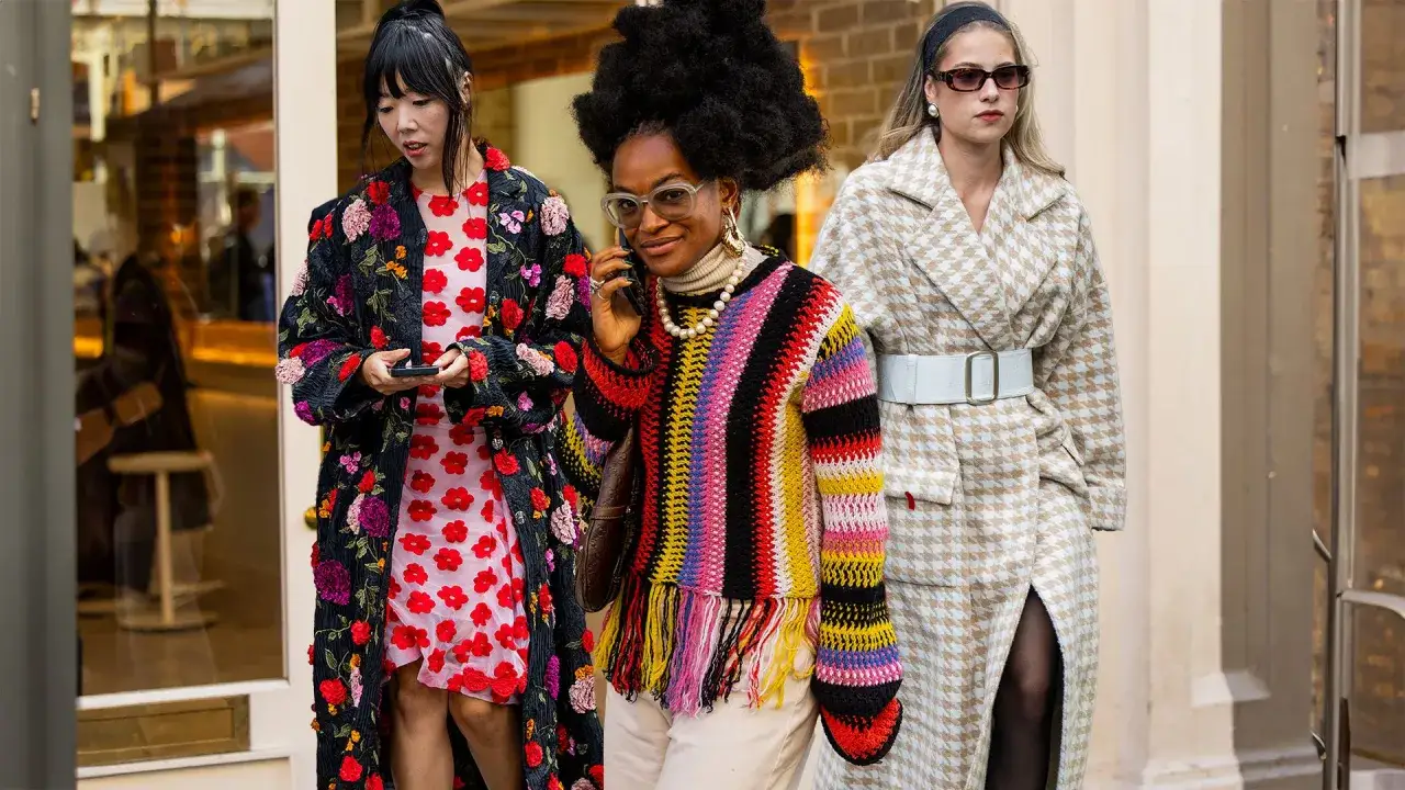 Three stylish women showcase a vibrant summer color palette. One wears a floral coat over a pink dress, another a colorful striped sweater, and the third a houndstooth coat.