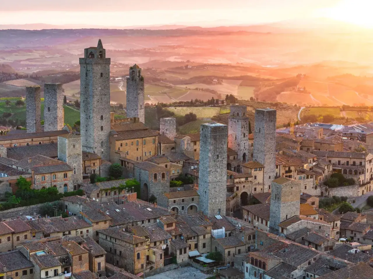 Torri medievali di San Gimignano al tramonto, un invito a visitare questo gioiello toscano.