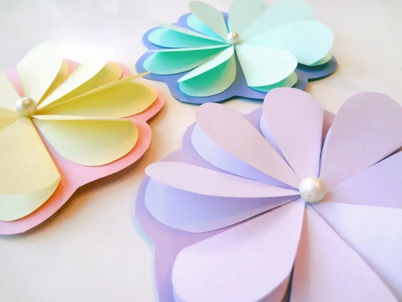Pyssel vårblommor i pastellfärger. Tre vackra pappersblommor med pärlor i mitten, perfekta för vårens dekorationer.