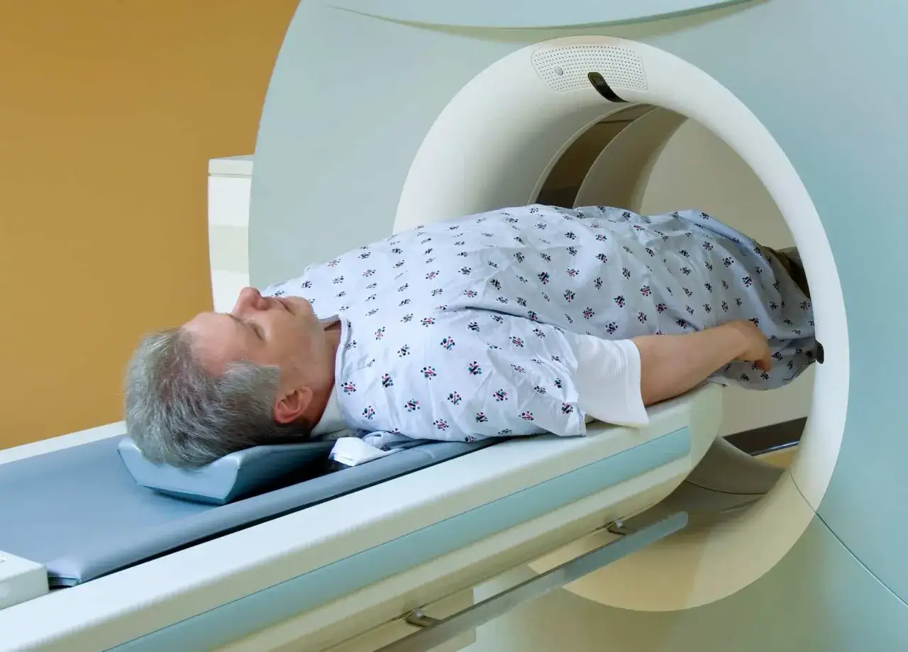 Homme allong&eacute; dans un appareil d'IRM pour un examen de la prostate.