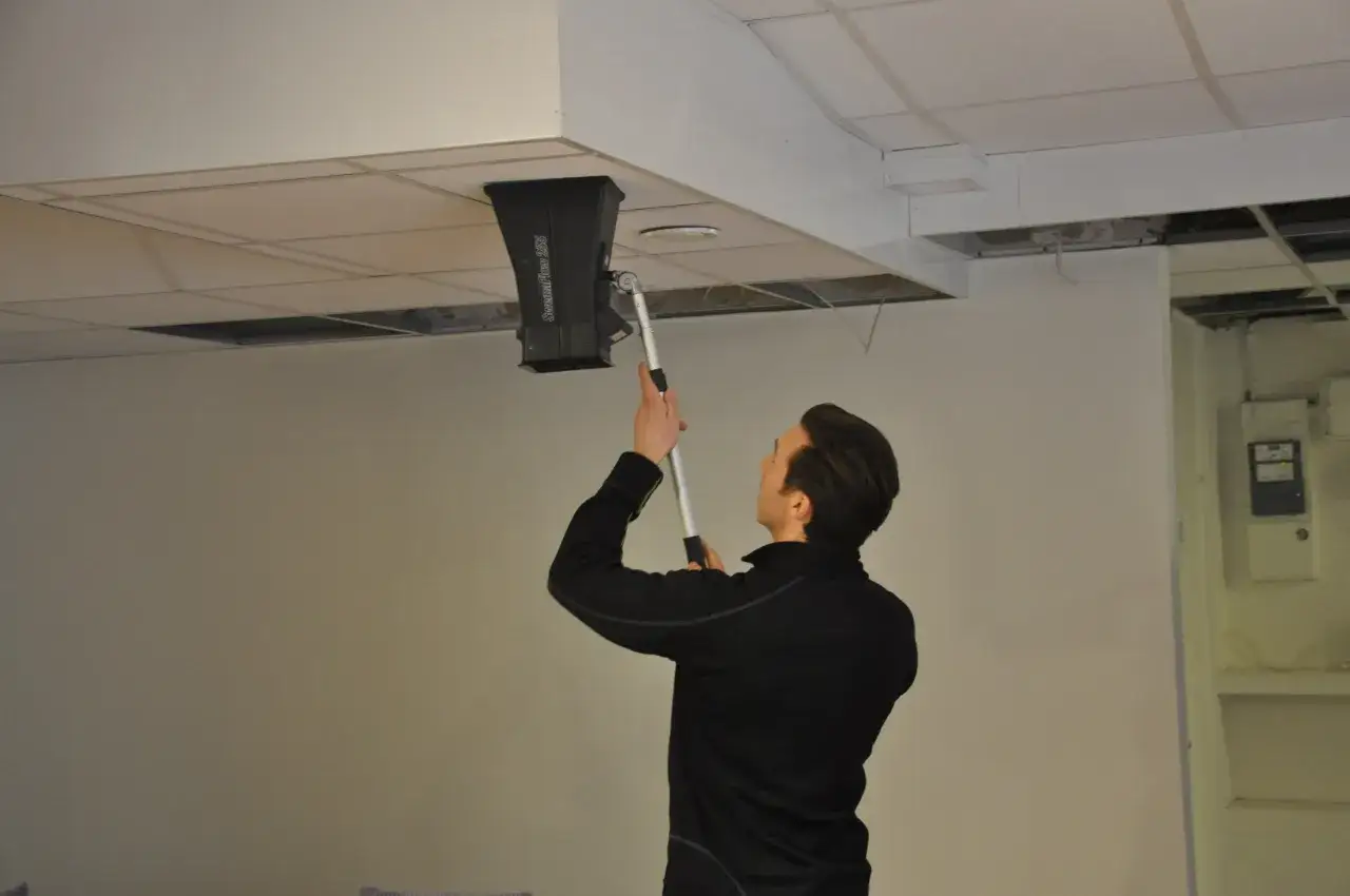 Man utf&ouml;r obligatorisk ventilationskontroll med m&auml;tutrustning i taket.