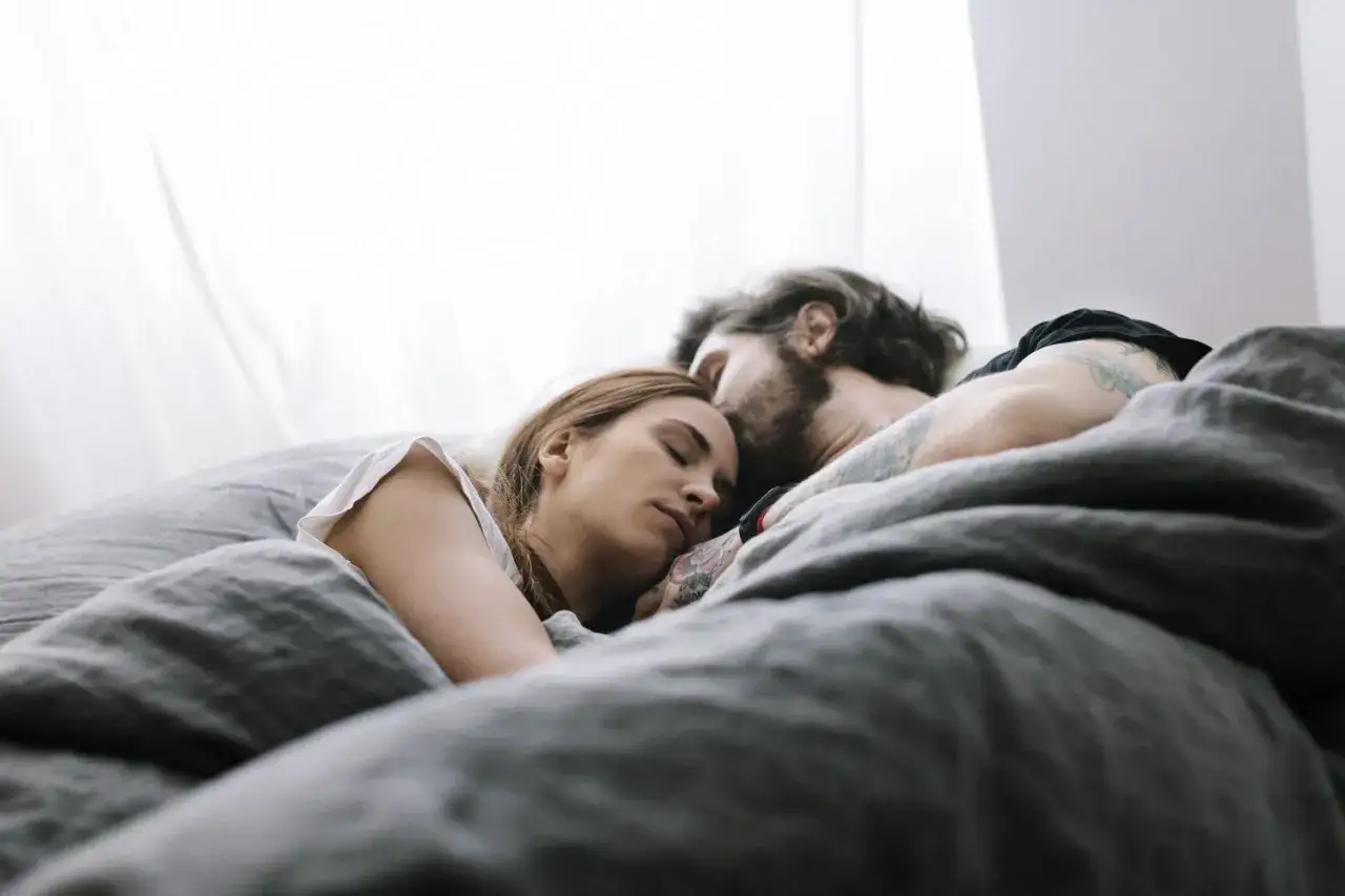 Para śpi wtulona w siebie, otulona pościelą. Może śnią o sobie, o gorących sny erotyczne.