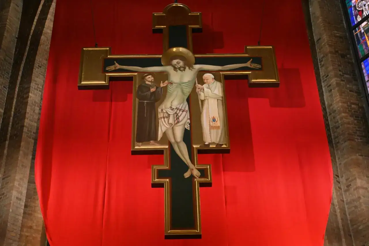 Obraz przedstawia krucyfiks z Jezusem, św. Franciszkiem i papieżem Janem Pawłem II. Zastanawiasz się, ile trwa nabożeństwo wielkopiątkowe?