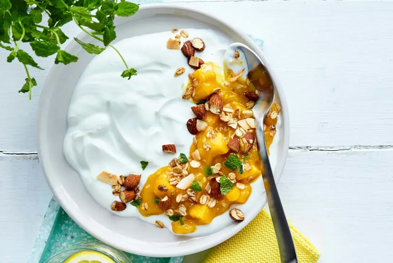En sk&aring;l med kr&auml;mig yoghurt, mango, mandlar och flingor. Ett perfekt granola recept f&ouml;r en frisk start.