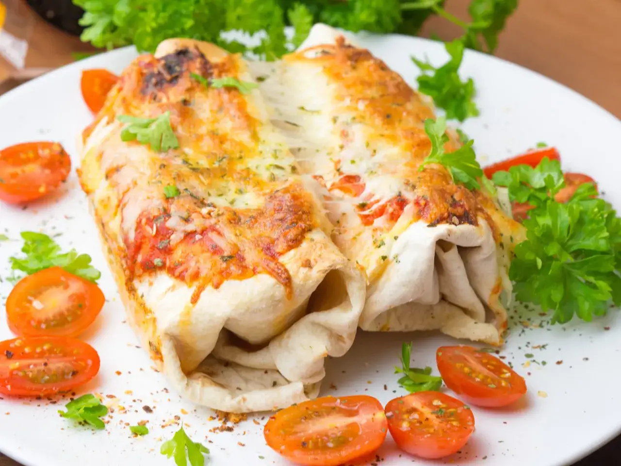 Pyszna tortilla z piekarnika, zapieczona z serem i pomidorami, udekorowana natką pietruszki.