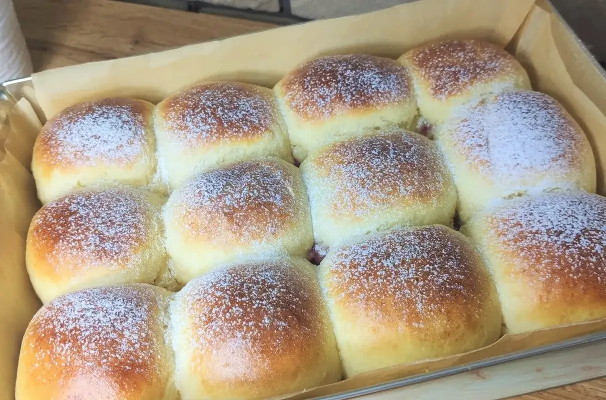 Szybkie słodkie bułeczki drożdżowe bez wyrastania, posypane cukrem pudrem, gotowe do jedzenia.