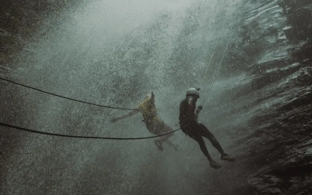Dw&oacute;ch ludzi zjeżdża na linach przez wodospad. To właśnie jest canyoning &ndash; ekstremalna przygoda!