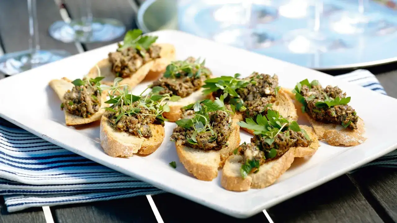 Små crostini med en härlig tapenade, toppade med färska örter. Perfekt som tilltugg!