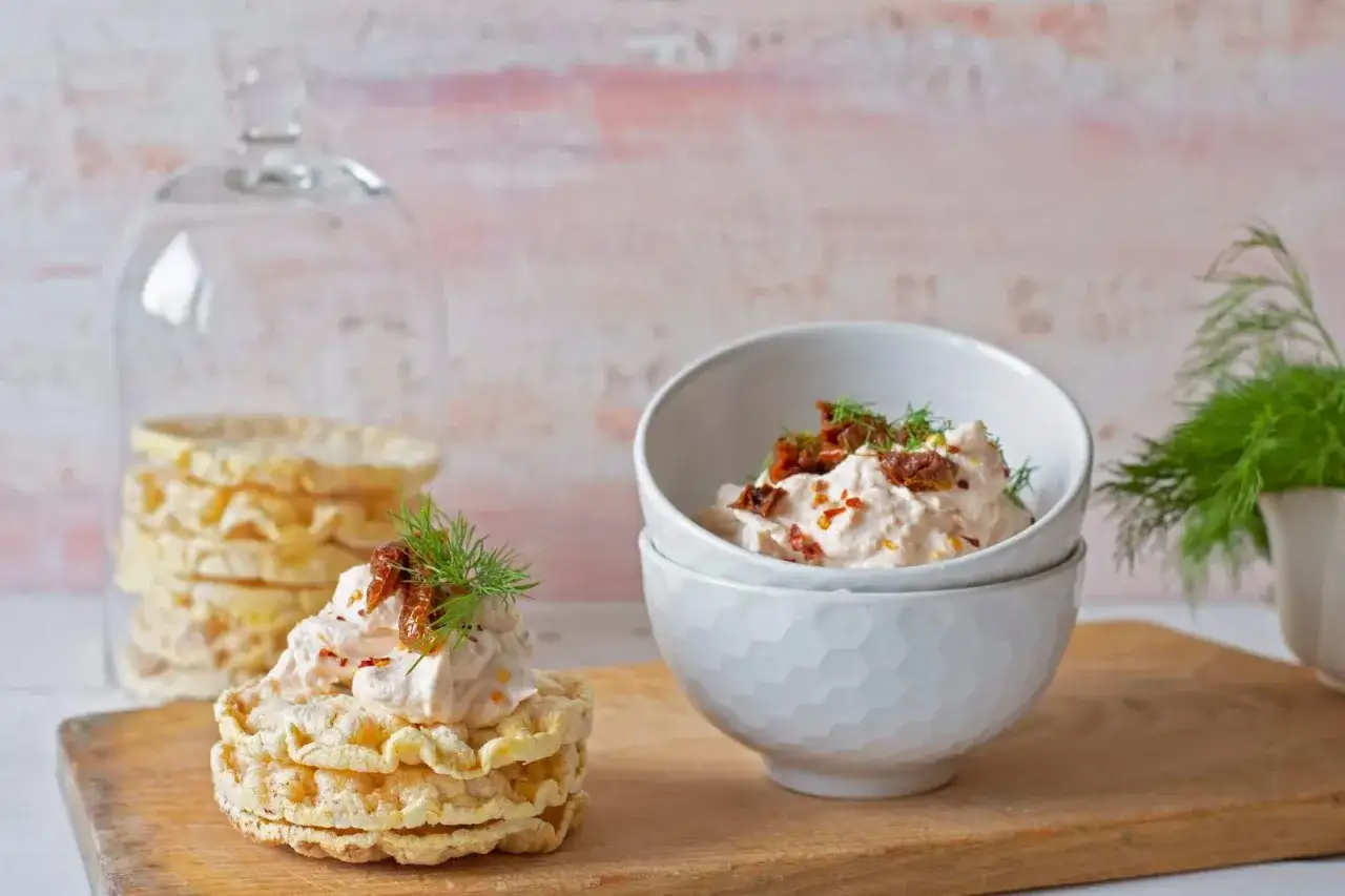 Pyszna pasta z łososia z suszonymi pomidorami i koperkiem na chrupkach ryżowych. Idealna na przekąskę.