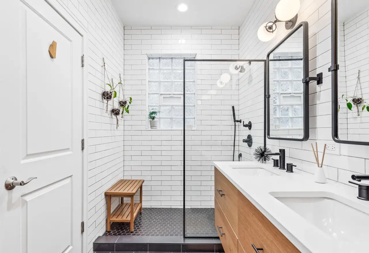 Salle de bain moderne avec deco wc noir et bois. Douche vitr&eacute;e, double vasque, miroir, et banc en bois.