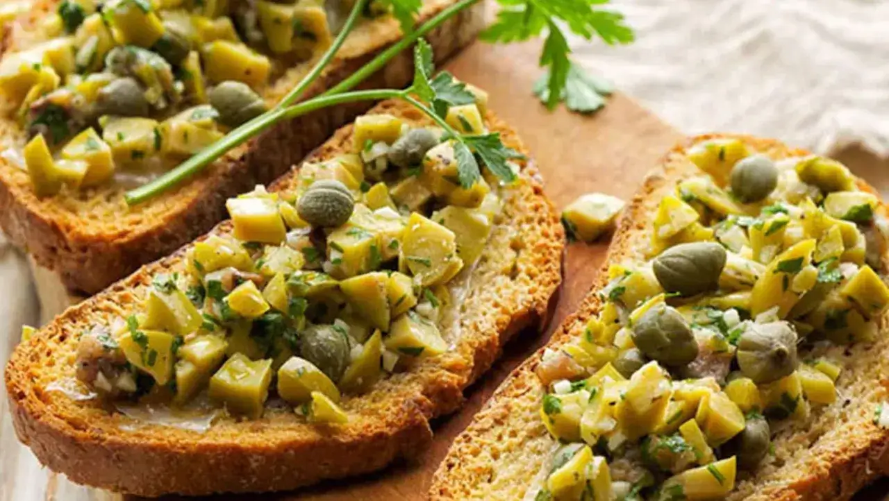 Tostadas con picadillo de aceitunas, alcaparras y hierbas, un delicioso aceite de oliva untable.