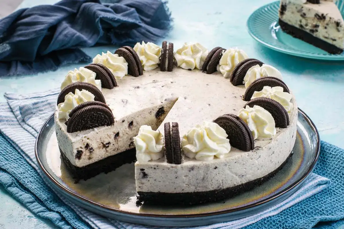 Una deliziosa torta oreo, con crema soffice e biscotti sbriciolati, decorata con ciuffi di panna e biscotti interi.