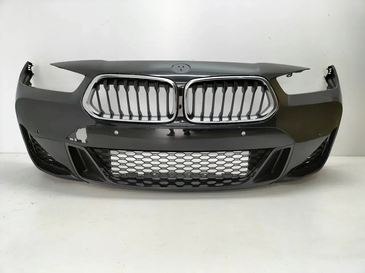 Zderzak BMW z pakietem M, z charakterystycznym grillem i sportowymi wlotami powietrza.