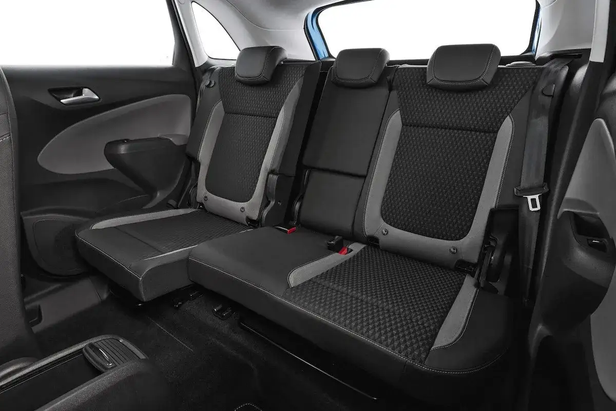 Asientos traseros del Opel Crossland X, con tapicer&iacute;a de tela gris y negra, listos para un viaje c&oacute;modo.