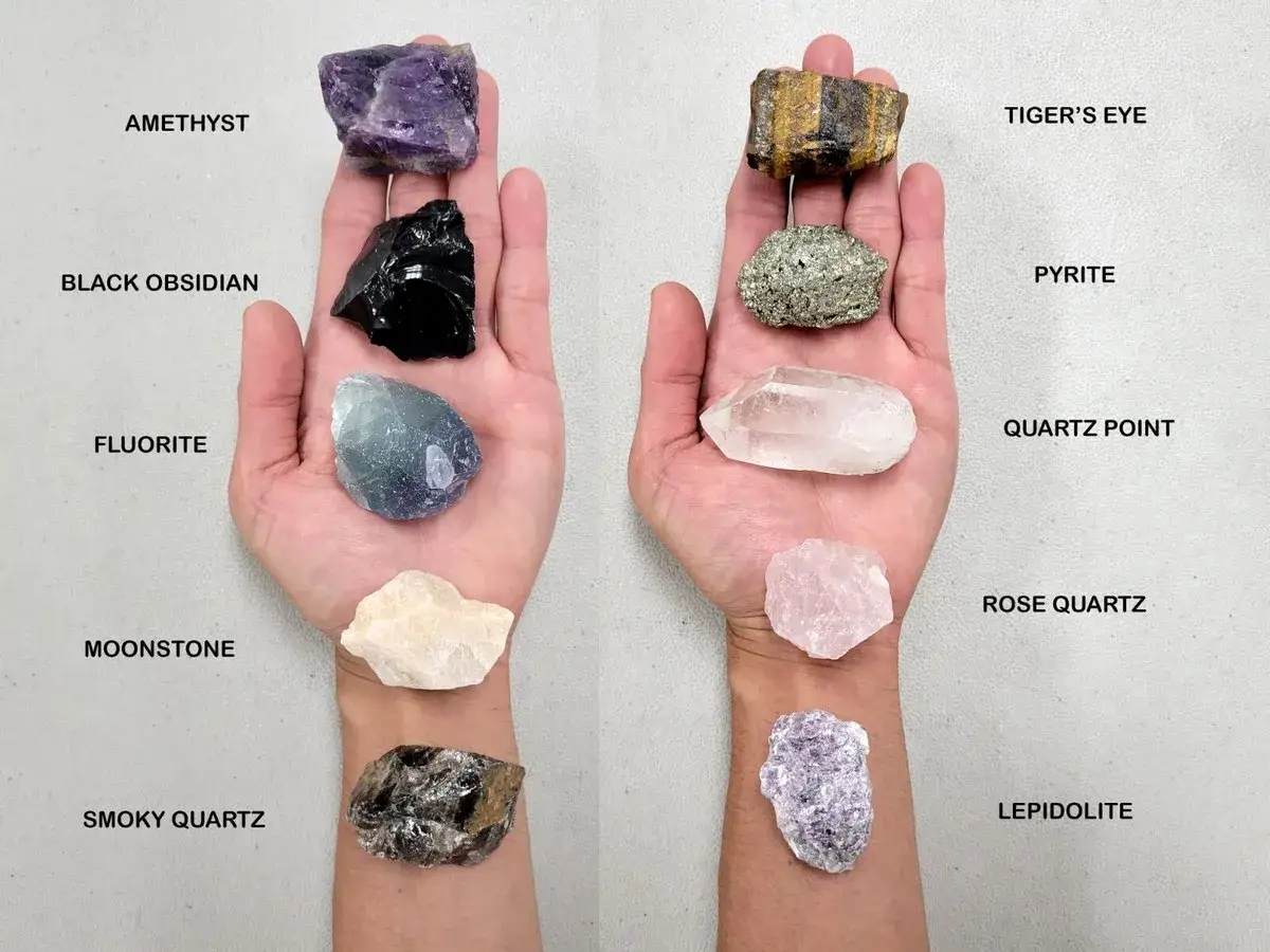 Hands display various healing stones. Rose Quartz, known for its gentle energy, is a popular stone that helps with healing.