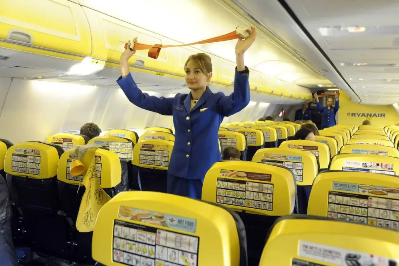 Stewardessa Ryanair demonstruje pasy bezpieczeństwa. Zastanawiasz się, ile zarabia stewardessa w Ryanair?