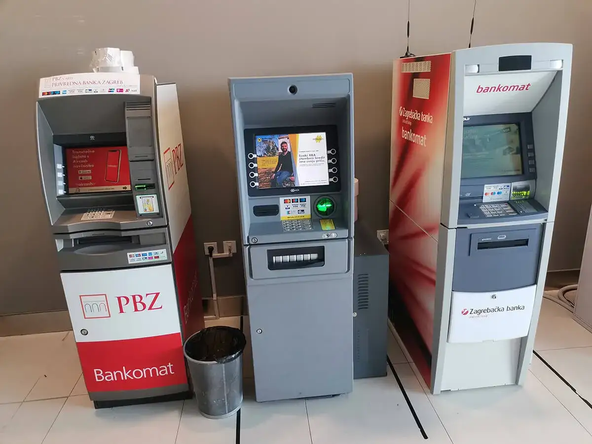 Trzy bankomaty w Chorwacji: PBZ, bankomat z ekranem i bankomat Zagrebačke banke. Waluta w Chorwacji dostępna w tych maszynach.