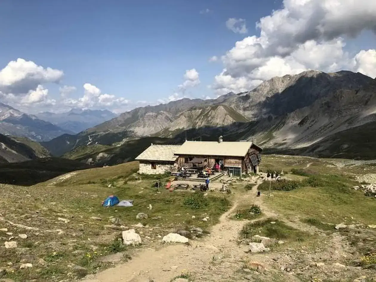 Refuge de montagne en France, idéal pour un trek 5 jours France. Des tentes sont installées à proximité.