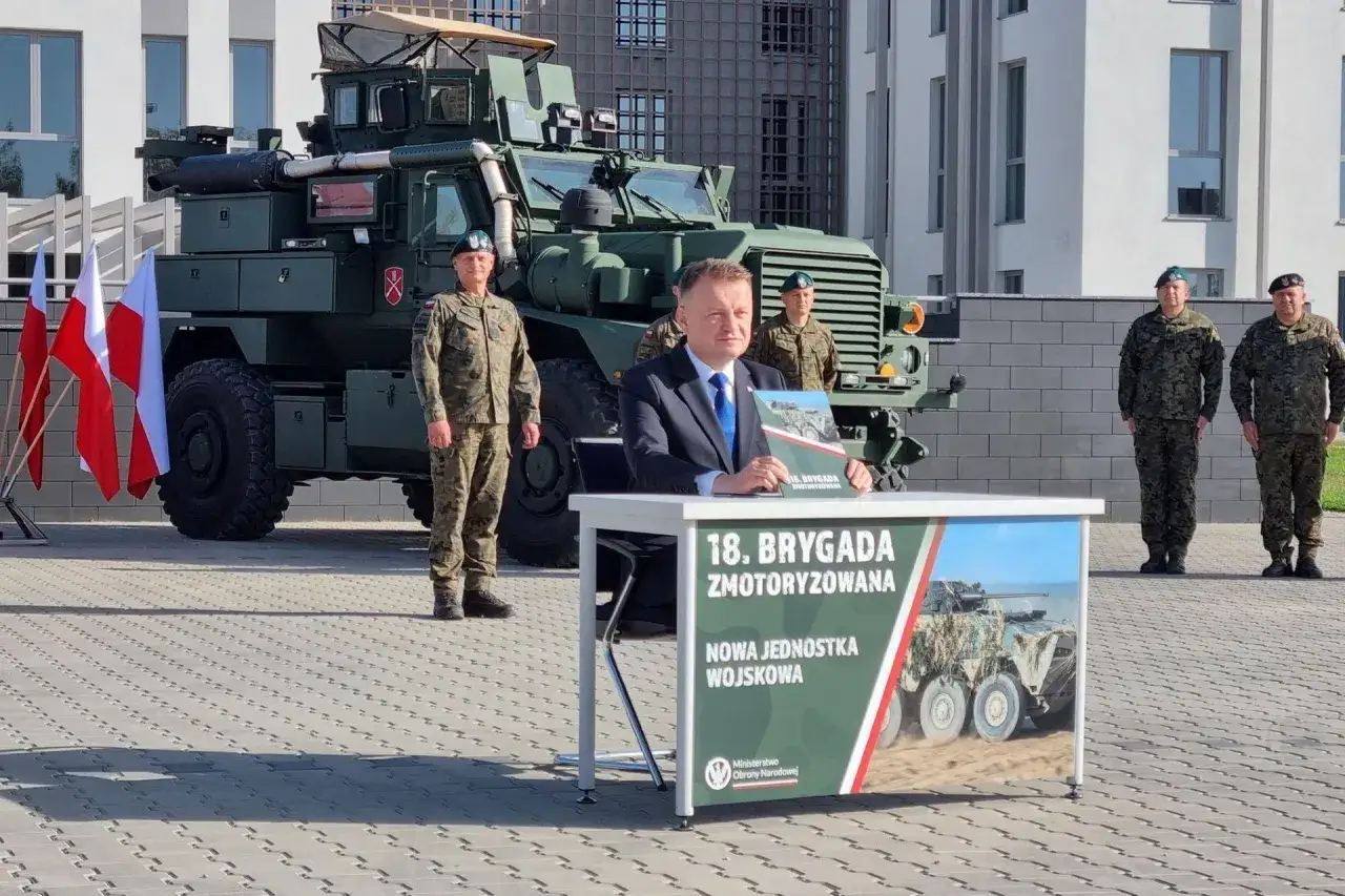 Uroczystość z udziałem 18. brygady zmotoryzowanej. Na pierwszym planie minister, za nim nowy pojazd wojskowy.