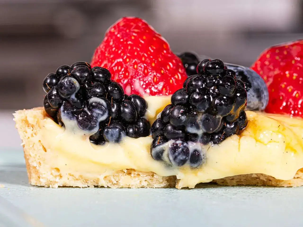 Tartelette aux fruits rouges et crème pâtissière, sublimée par un nappage neutre brillant.