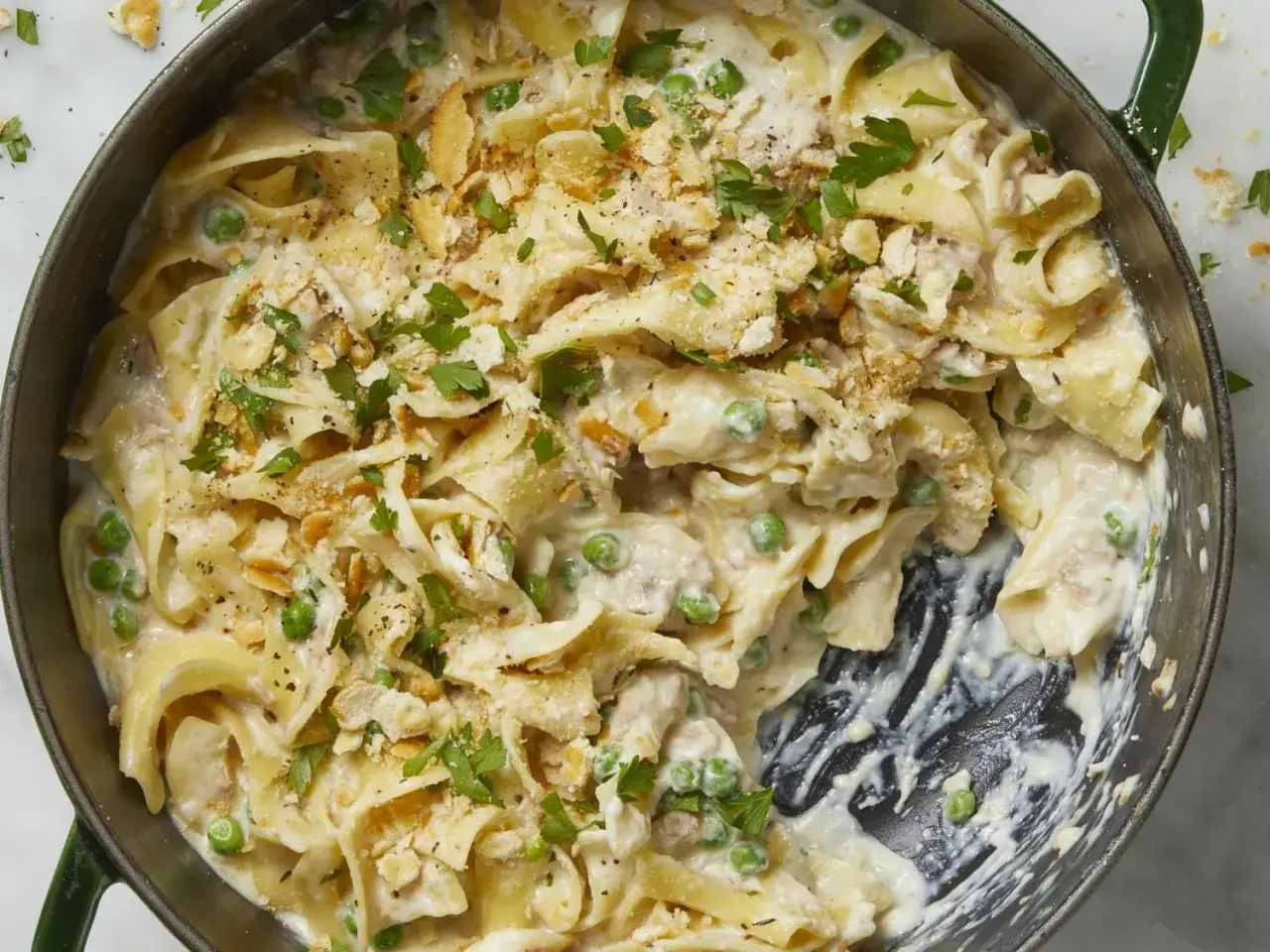Délicieuse recette thon en boite avec des pâtes larges, petits pois et chapelure croustillante, garnie de persil frais.