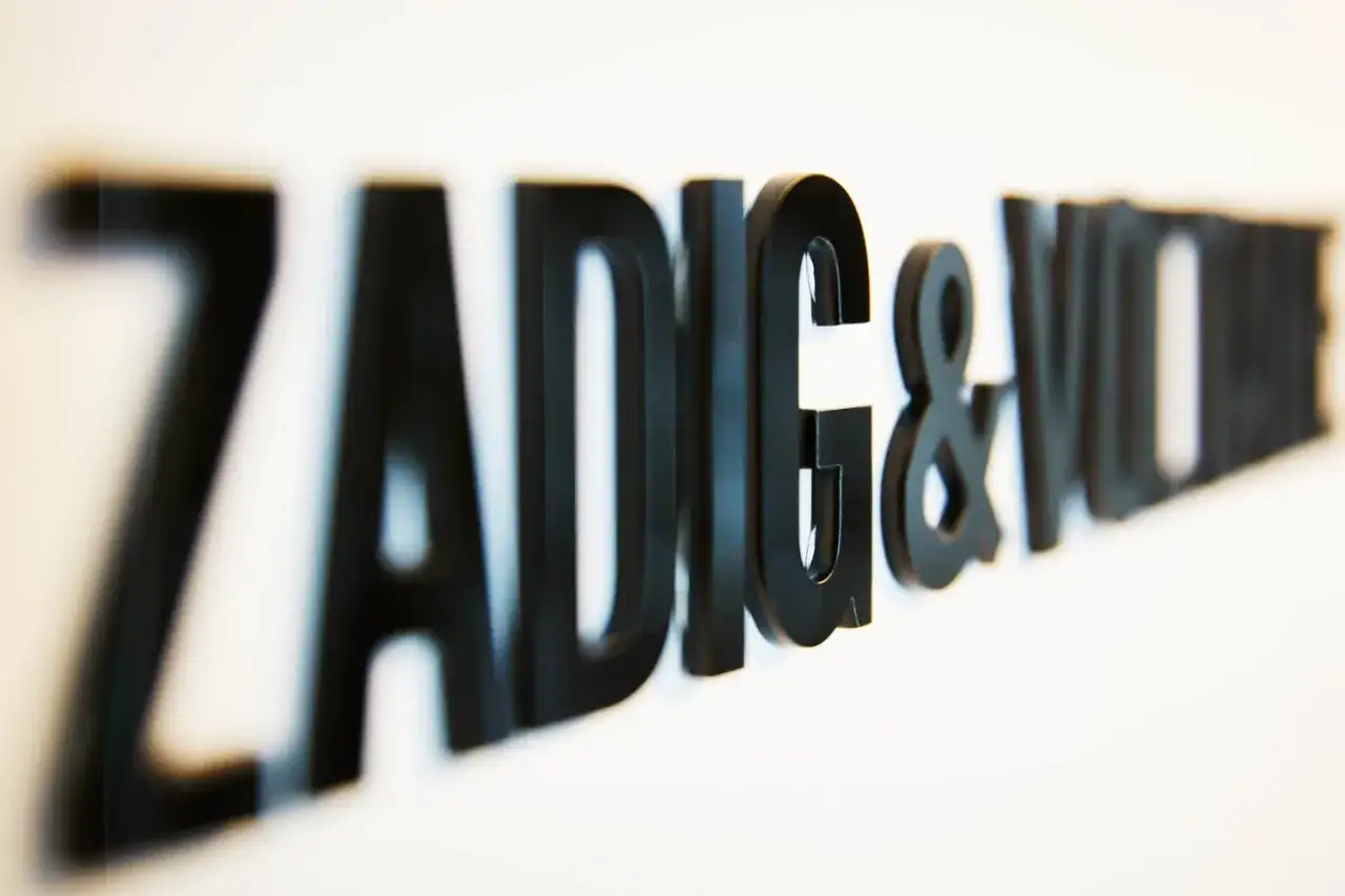 Lettre ZADIG & VOLTAIRE en plexiglas noir, en relief sur un mur blanc.