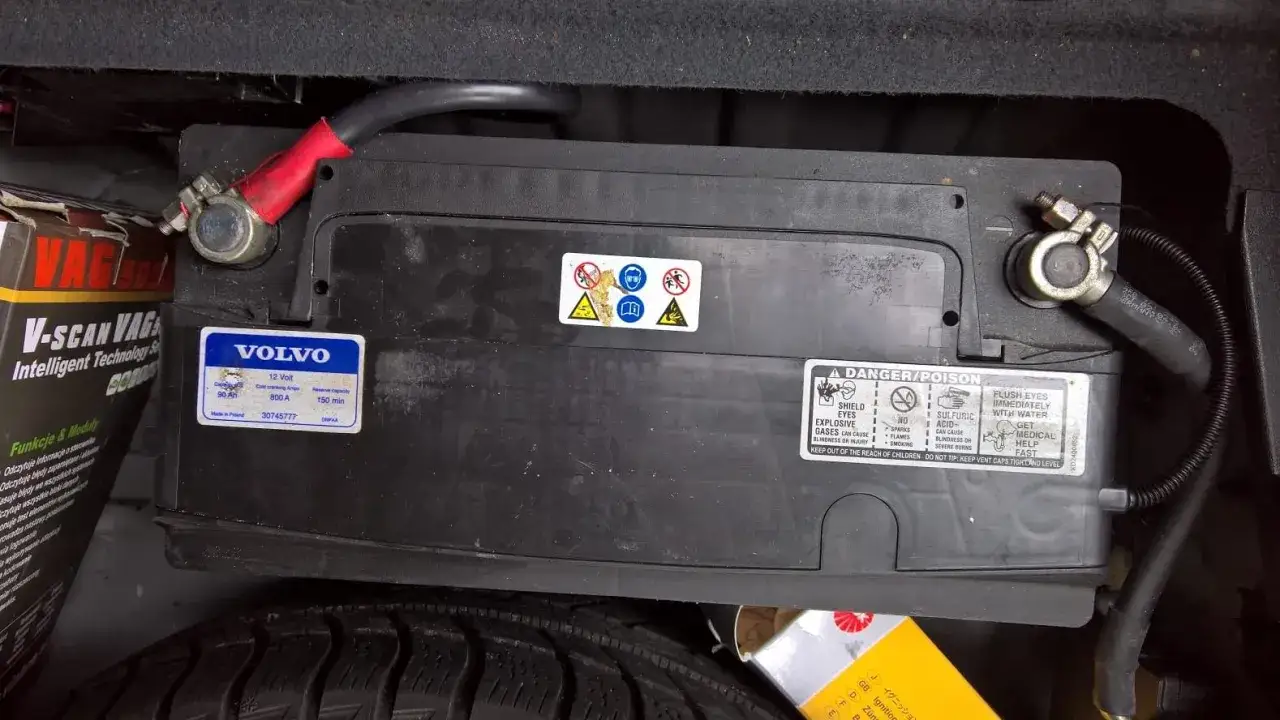 Akumulator Volvo 90Ah, 800A, idealny do Audi A6 C6. Widoczne oznaczenia bezpieczeństwa i kable.