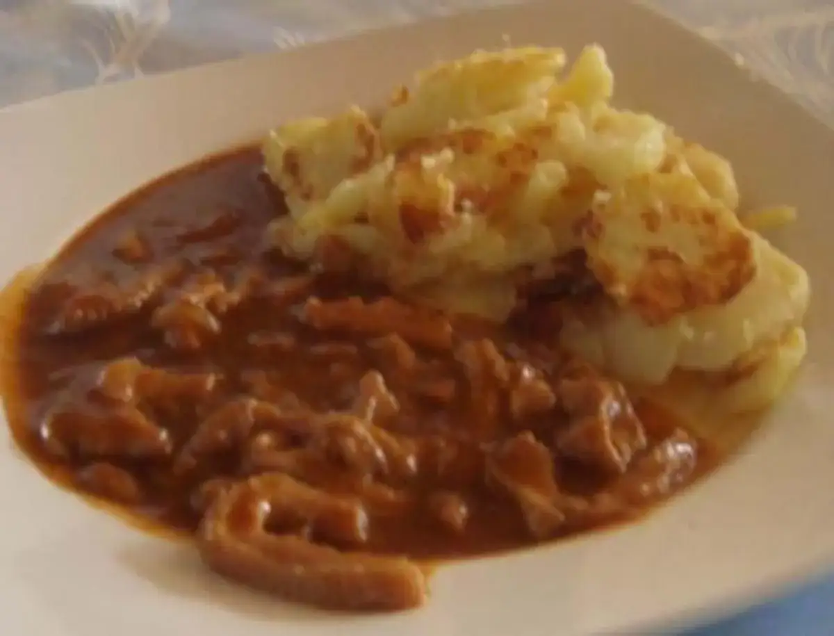Herzhaftes Kutteln Rezept mit Bratkartoffeln auf einem Teller.