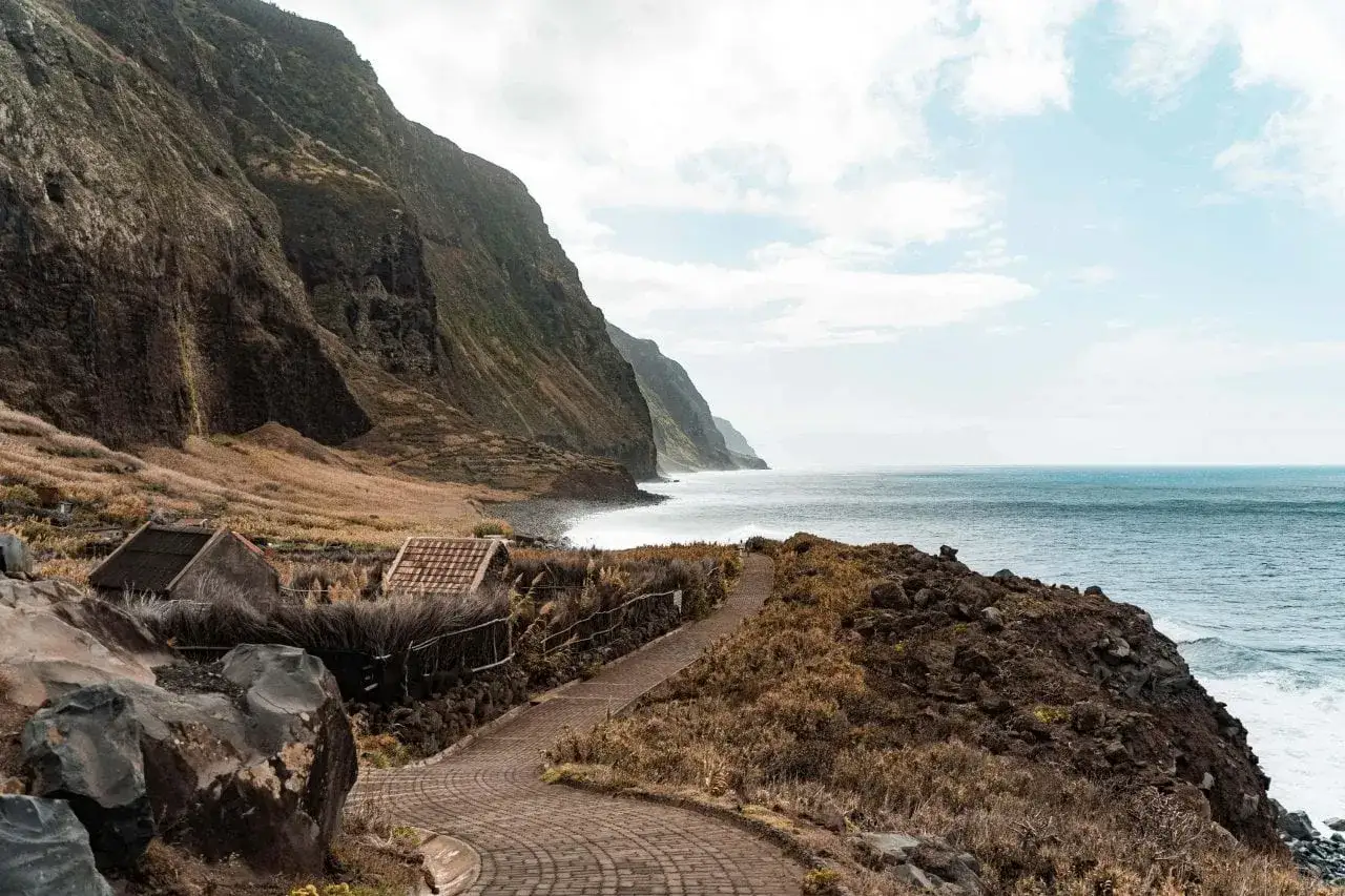 Steile Küsten und kleine Häuser am Meer – ein versteckter Ort auf Madeira, der zum Entdecken einlädt. Madeira Geheimtipps.