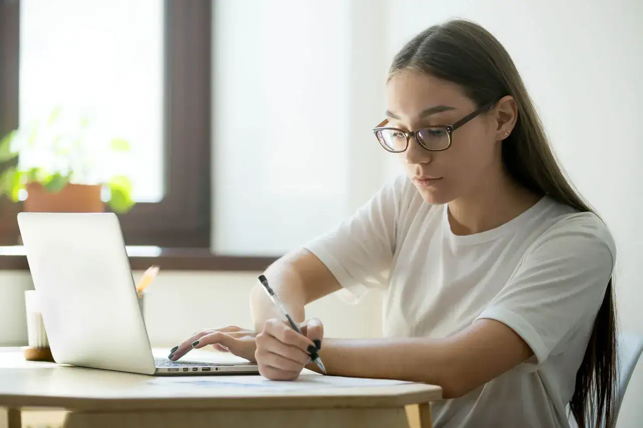 Estudiante concentrada en su port&aacute;til, investigando qu&eacute; es IGCSE para su futuro acad&eacute;mico.