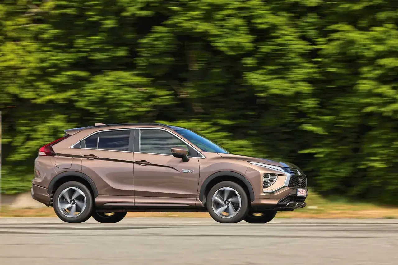 Brauner Mitsubishi Eclipse Cross fährt schnell, Hintergrund verschwimmt. Keine Probleme mit diesem SUV, nur Fahrspaß.
