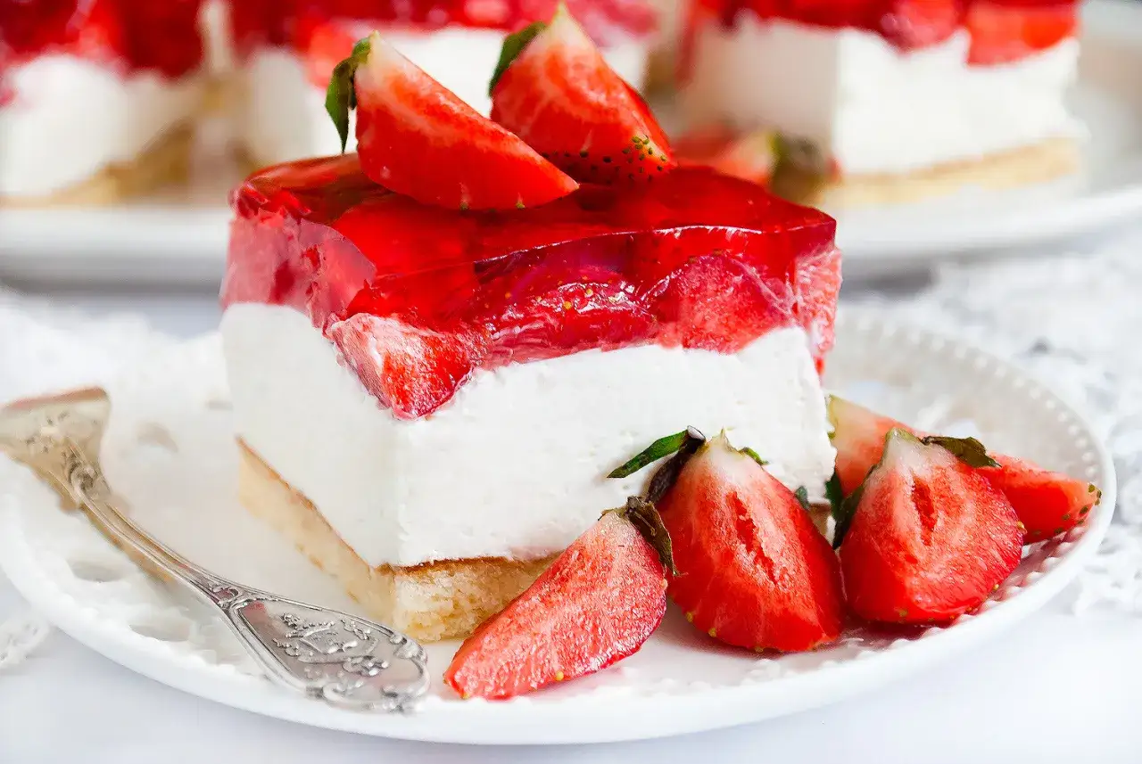 Pyszne ciasto z mascarpone i truskawkami, pokryte galaretką. Idealne na letnie popołudnie.