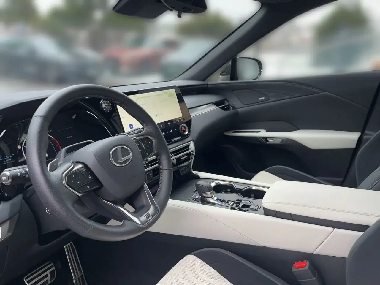 Wnętrze Lexus RX 450h: kierownica, ekran nawigacji i eleganckie, dwukolorowe wykończenie.