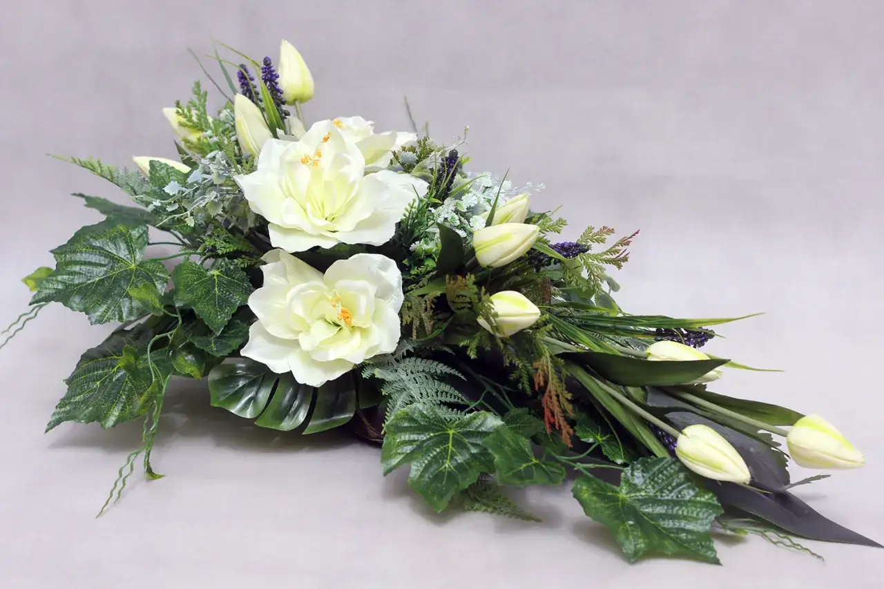 Białe kwiaty i tulipany tworzą elegancką kompozycję na cmentarz.