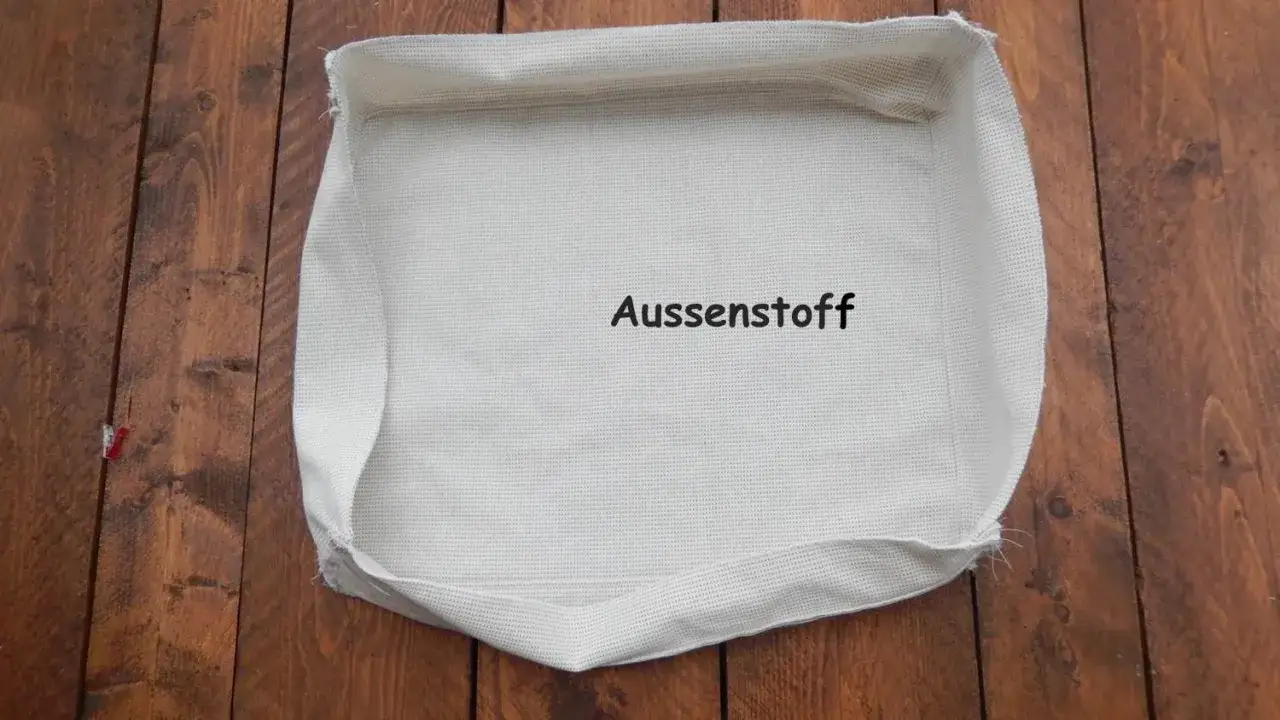 Stoff f&uuml;r ein **Sitzkissen selber machen**: Ein wei&szlig;er Au&szlig;enstoff liegt auf Holzbrettern.
