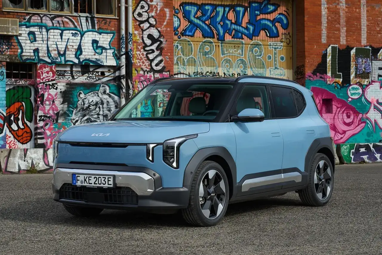 Niebieski samochód Kia EV6 na tle kolorowego graffiti. Nowe kia modele w miejskim krajobrazie.